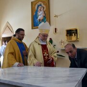 Kierownik budowy, pan Mhitar, fachowo wmurowuje dekret.